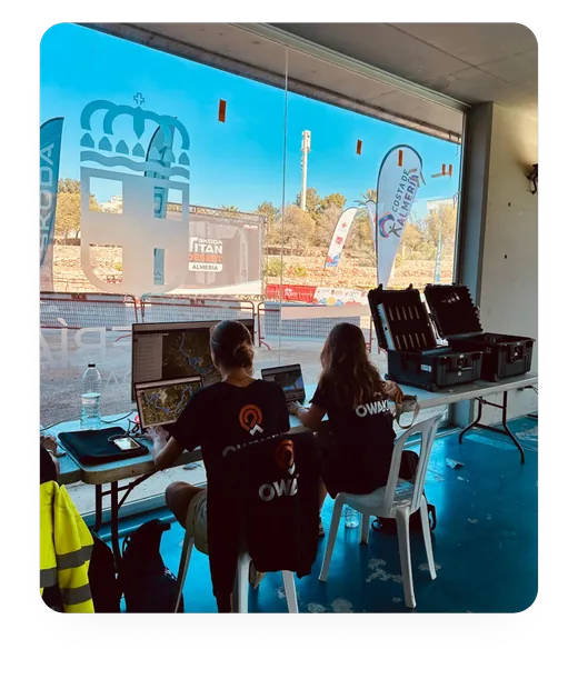 Two Owaka team members follow a race on their laptops near the finish line